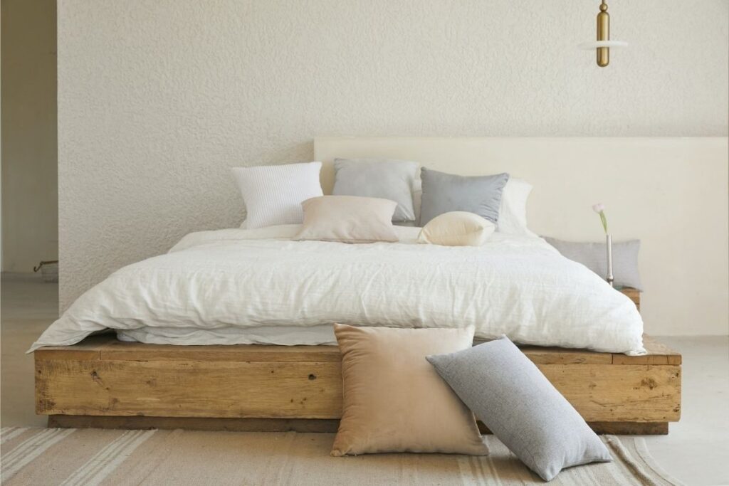 white muted colors bed pillow on brown wooden bed frame