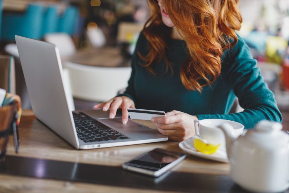 redhead making purchase with credit card