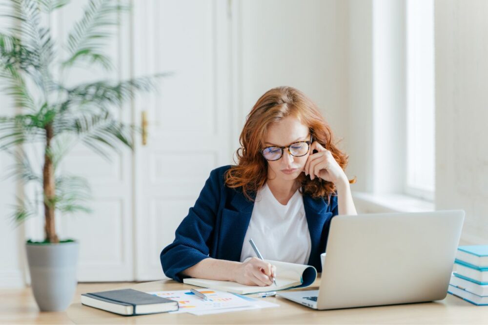 Redheaded woman working at her desk