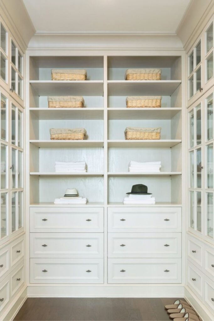 Large white built-in closet with shelves and glass doors