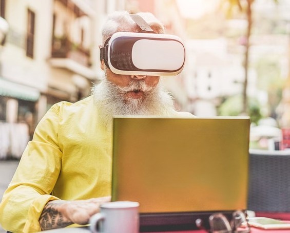 Bearded mature man wearing virtual reality goggles in bar outdoor - Senior trendy male using vr headset