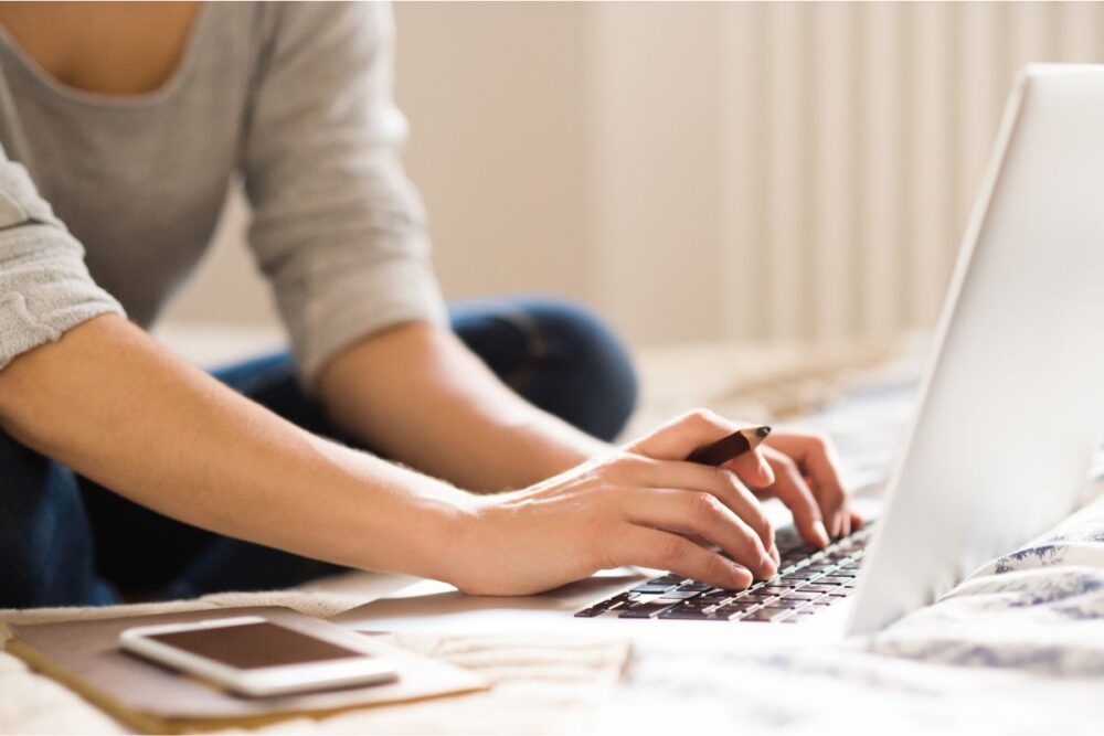 woman on bed working on laptop