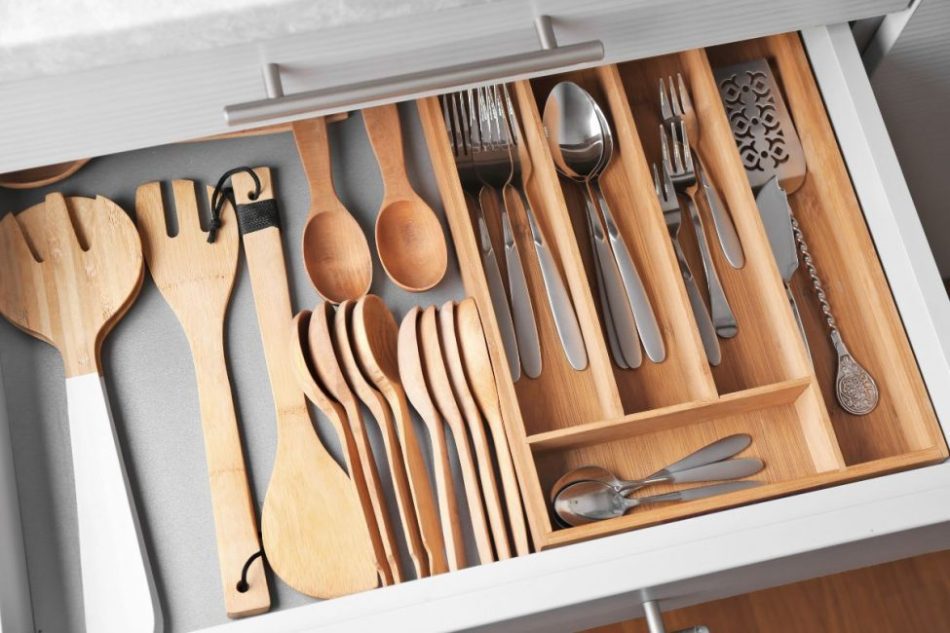 A drawer of kitchen utensils organized by type and size using a drawer organizer.