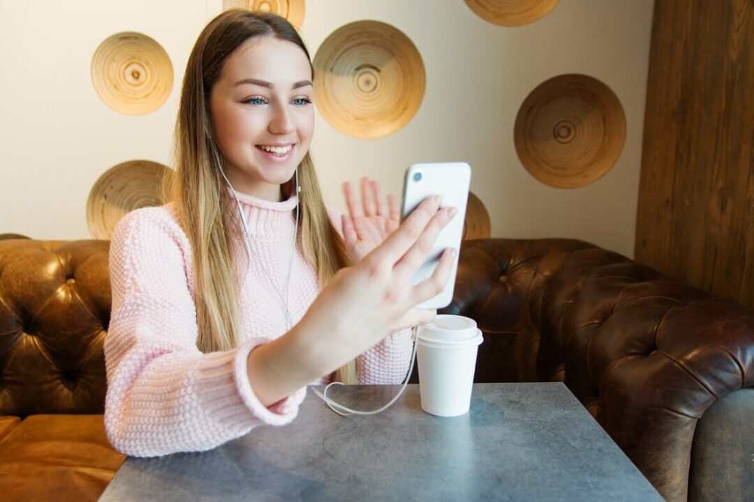 woman waving on cell phone video call