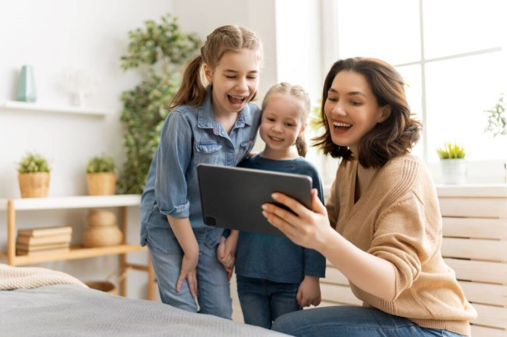 mother two daughters video calling tablet