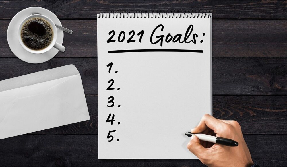 2021 Goals List with coffee cup on wood table