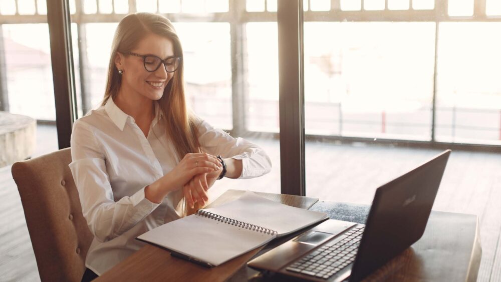 Woman with Planner laptop checking watch