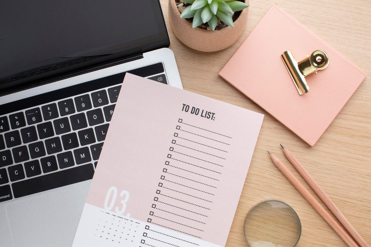 To Do list planner on a desk layered with a computer, pencils, and other office supplies