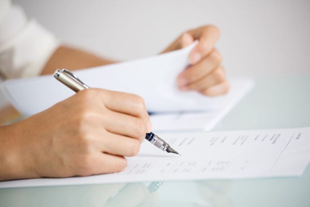 closeup hands holding paper pen
