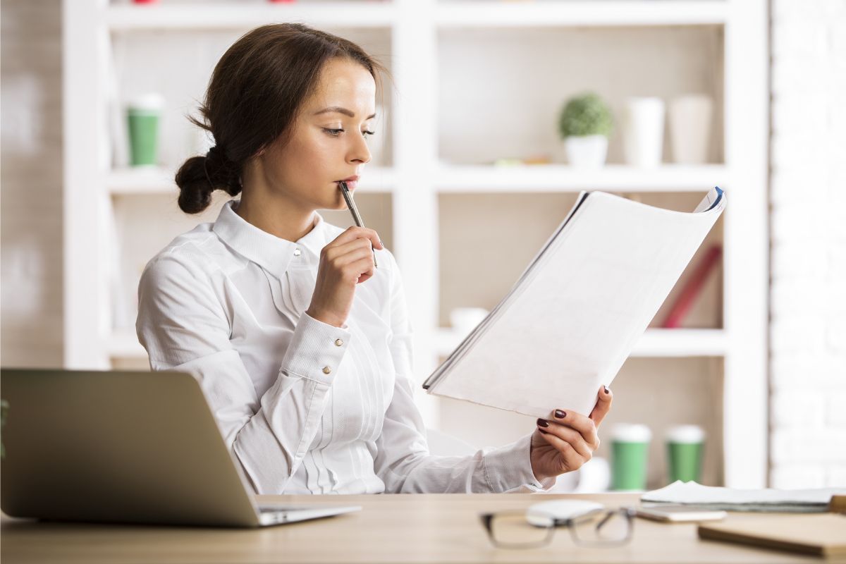 woman reading paperwork at desk