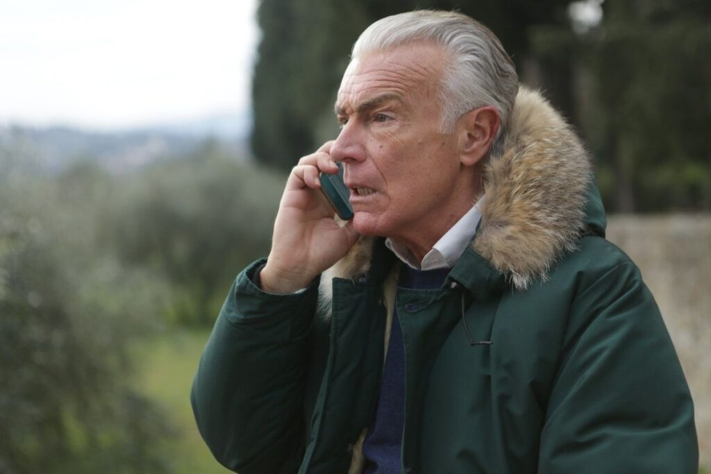 Older Man in Green Jacket Holding Phone