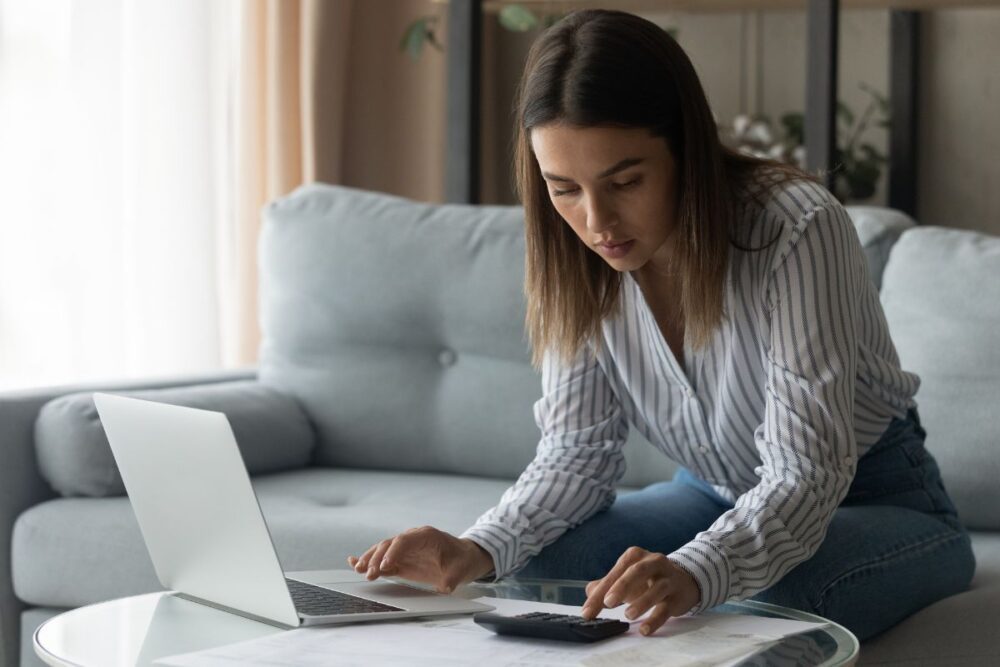 woman sitting with laptop and calculator
