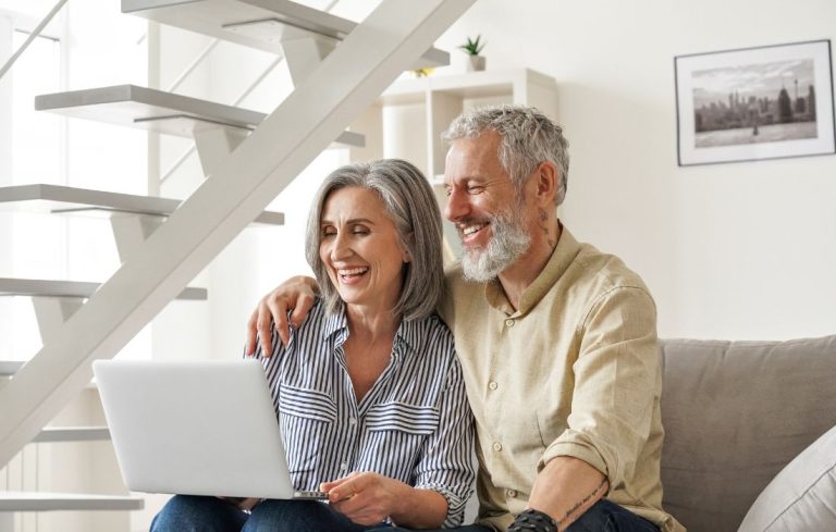 Retired couple at home on laptop