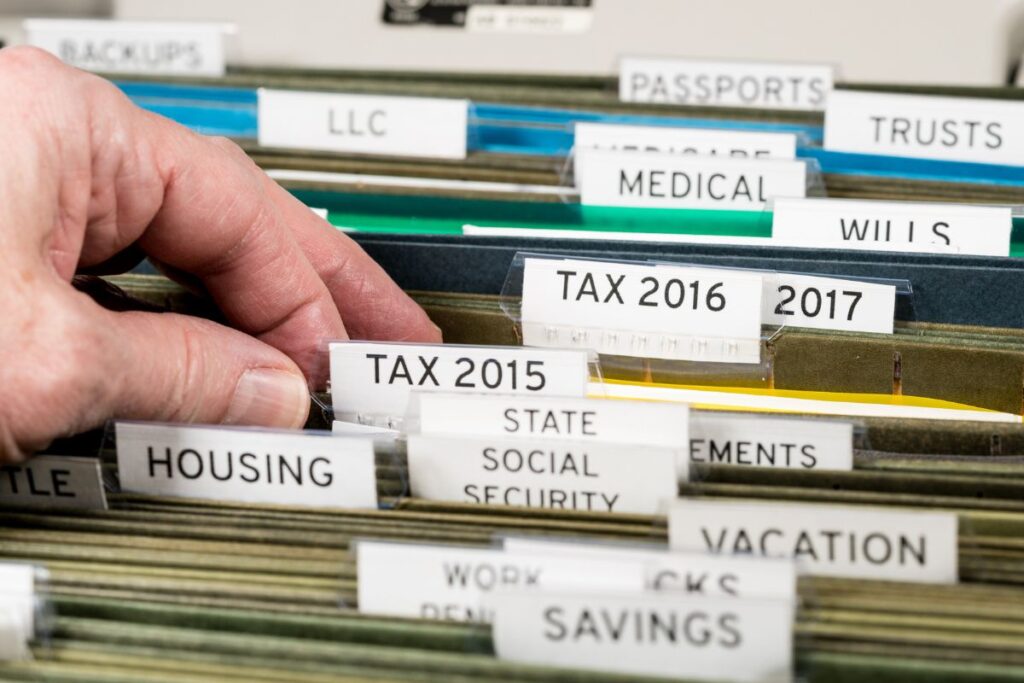 A filing system with labeled tabs like "tax 2016" "social security" and "savings."
