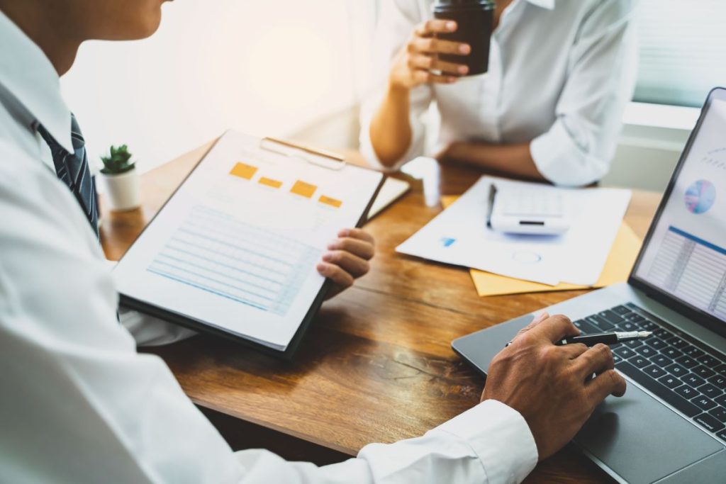 Two people sitting at a desk going over a credit report