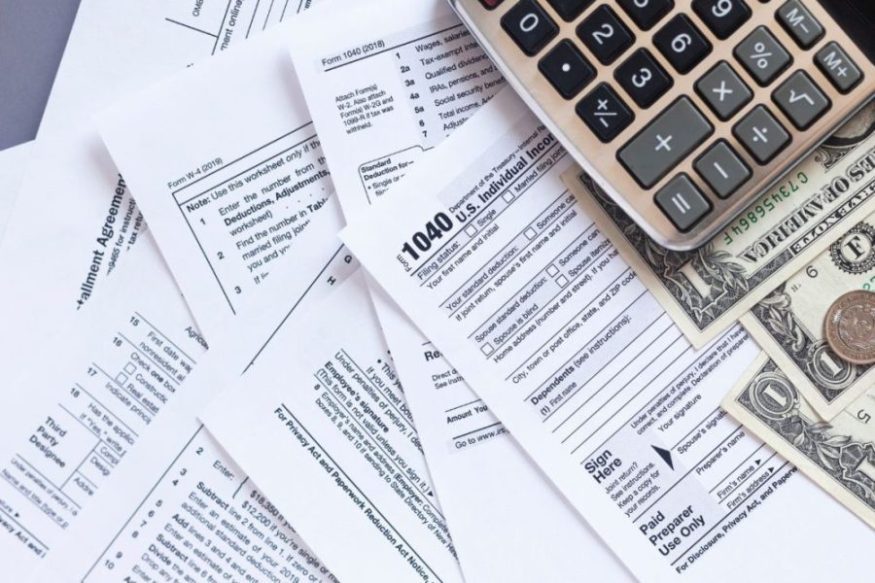 tax documents in a pile with a calculator