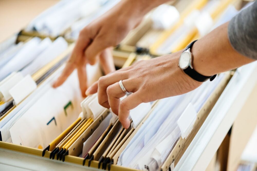 Sort through a filing cabinet to look for important documents